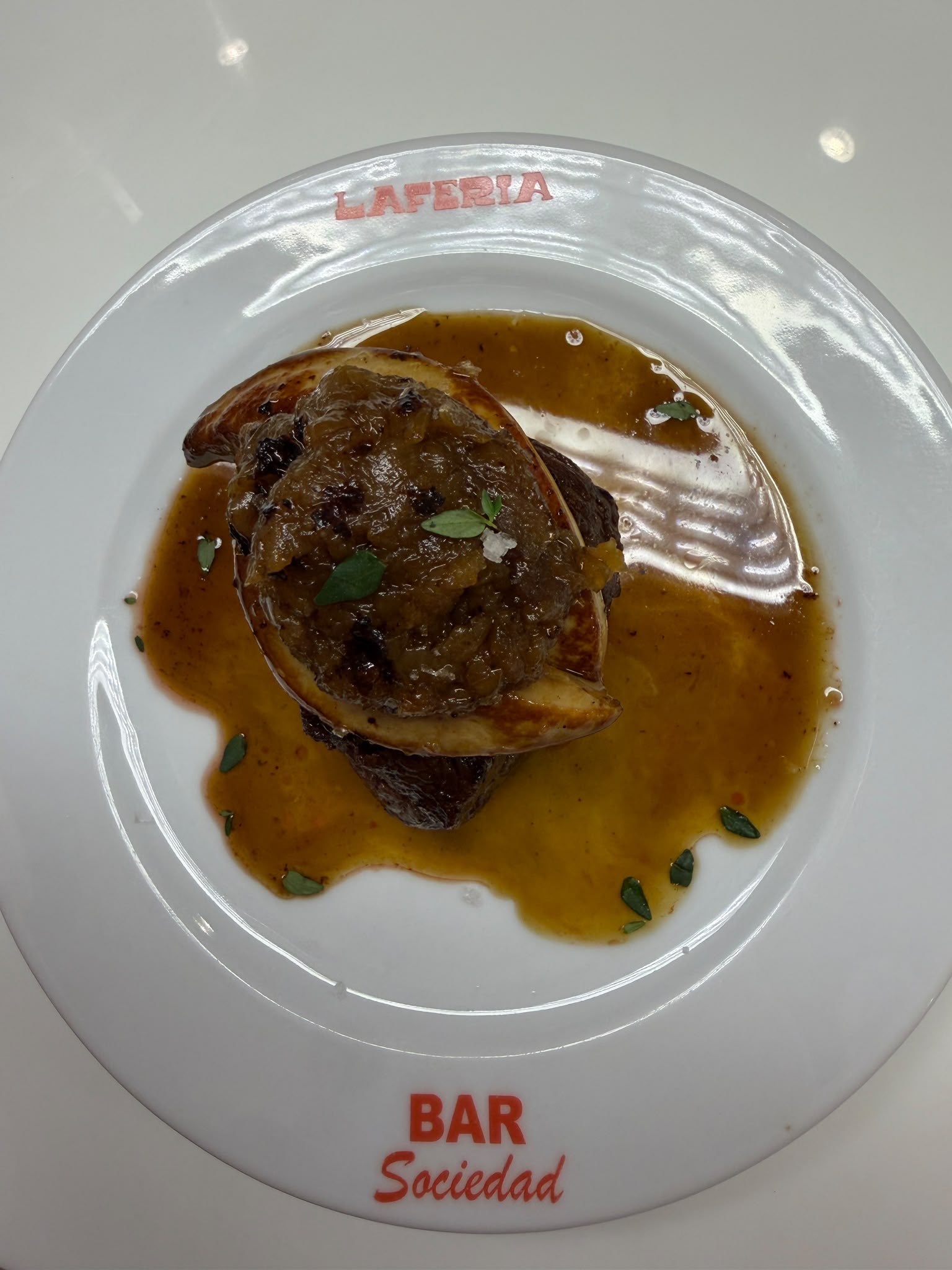 Meat topped with cooked onions and sauce at Bar Sociedad Laferia