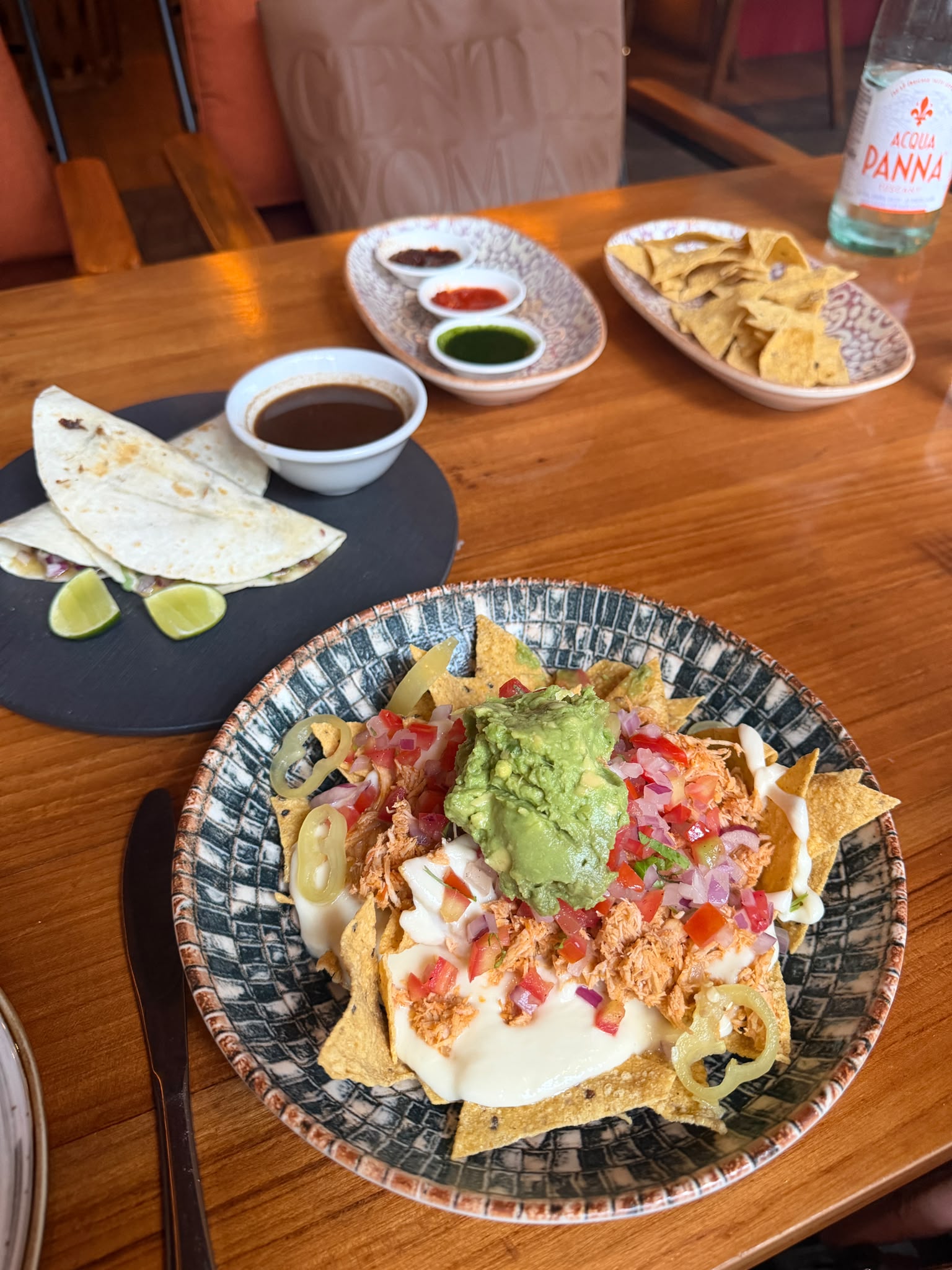 Nachos, quesadillas, tortilla chips, and sauces on a table at El Santo Bangkok
